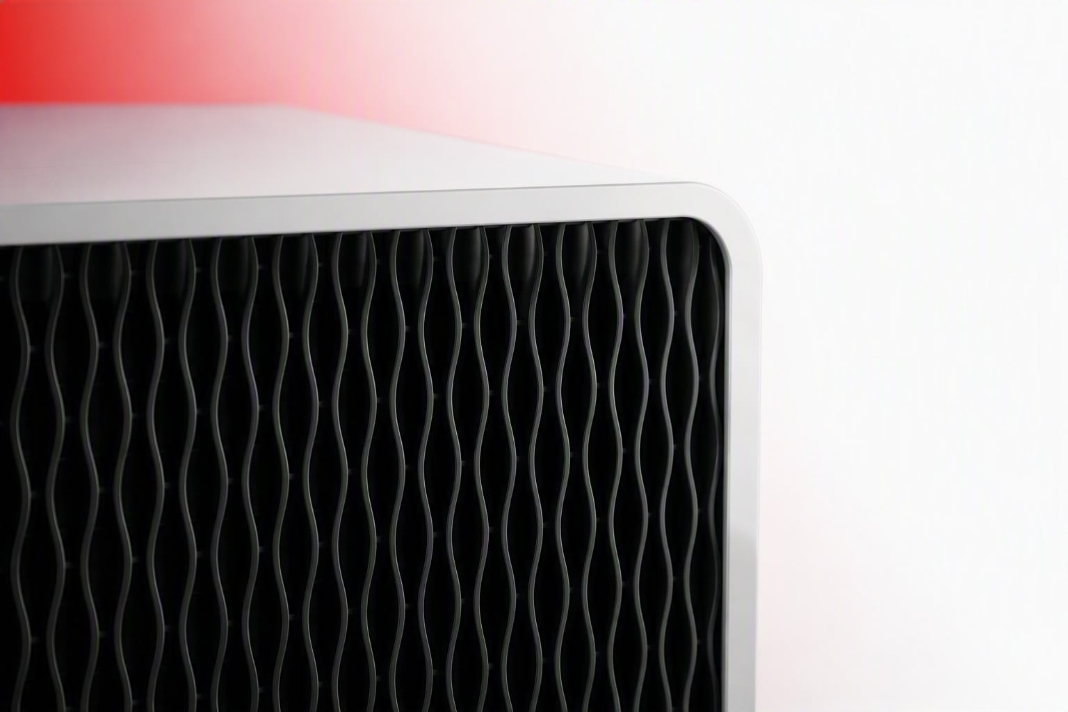 Detailed close-up of a portable air conditioner featuring a distinctive black wave-pattern front grille and clean white housing.