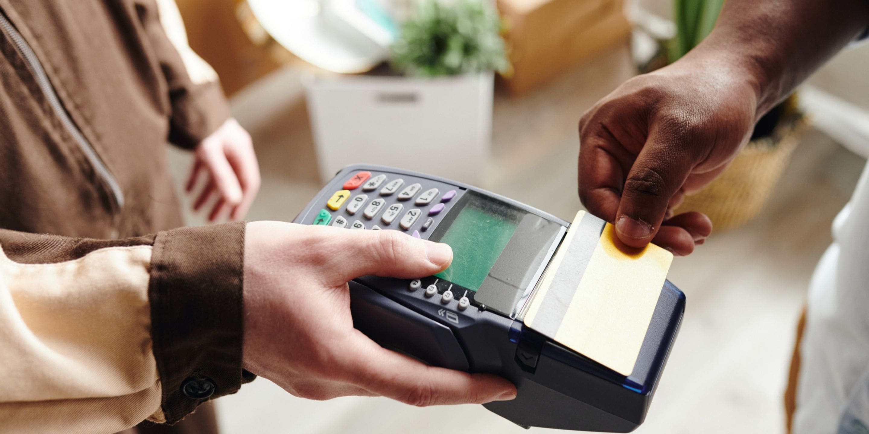 A person taps a credit or debit card on a card-reader at a store.